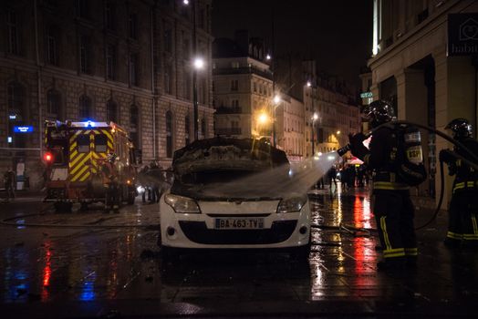 FRANCE, Paris: French firefighters extinguish a fire on an unmarked police vehicle near the Place de la République in Paris following violent protests during rally by the Nuit Debout (Up All Night) movement, on April 23, 2016. The Nuit Debout or Up All Night protests began in opposition to the Socialist government's labour reforms seen as threatening workers' rights, but have since gathered a number of causes, from migrants' rights to anti-globalisation.
