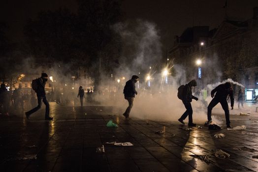 FRANCE, Paris: Nuit Debout protesters stand among smoke on the Place de la République in Paris during violent protests following the Nuit Debout (Up All Night) movement rally, on April 23, 2016. The Nuit Debout or Up All Night protests began in opposition to the Socialist government's labour reforms seen as threatening workers' rights, but have since gathered a number of causes, from migrants' rights to anti-globalisation.