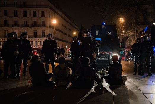 FRANCE, Paris: Nuit Debout protesters face riot police officers on the Place de la République in Paris during violent protests following the Nuit Debout (Up All Night) movement rally, on April 23, 2016. The Nuit Debout or Up All Night protests began in opposition to the Socialist government's labour reforms seen as threatening workers' rights, but have since gathered a number of causes, from migrants' rights to anti-globalisation.