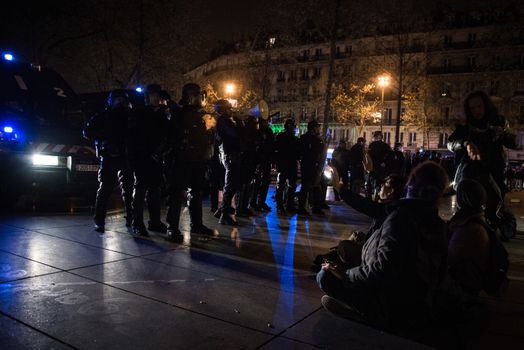 FRANCE, Paris: Nuit Debout protesters face riot police officers on the Place de la République in Paris during violent protests following the Nuit Debout (Up All Night) movement rally, on April 23, 2016. The Nuit Debout or Up All Night protests began in opposition to the Socialist government's labour reforms seen as threatening workers' rights, but have since gathered a number of causes, from migrants' rights to anti-globalisation.