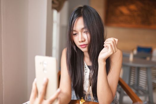 Home, technology and lifestyle concept - A women using smartphone for capture selfie .