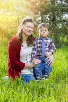 beautiful pregnant woman outdoor with her little boy