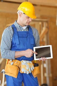 Construction worker pointing at digital tablet close-up