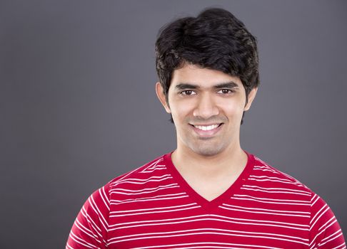 handsome east indian man wearing red shirt on light grey background