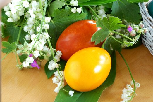 two brown and yellow easter eggs on the table with may-lily flowers