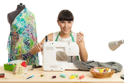 the seamstress sews a product on a table on the sewing machine