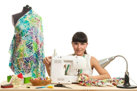 the seamstress sews a product on a table on the sewing machine