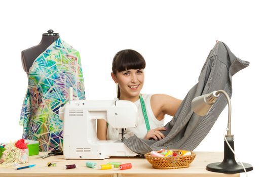 the seamstress sews a product on a table on the sewing machine