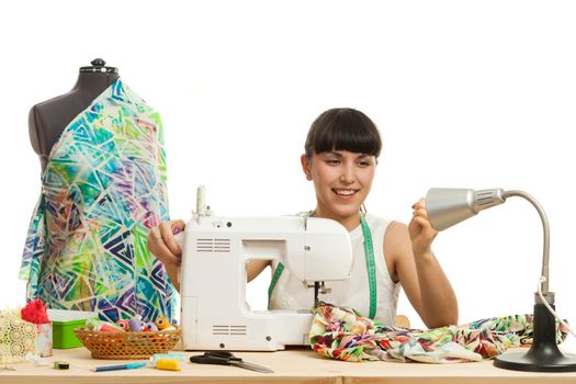 the seamstress sews a product on a table on the sewing machine