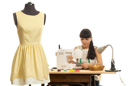 the seamstress sews a product on a table on the sewing machine