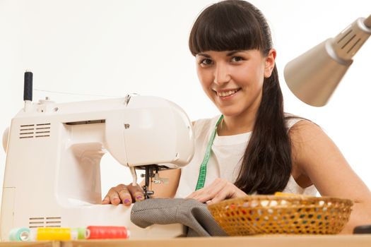 the seamstress sews a product on a table on the sewing machine