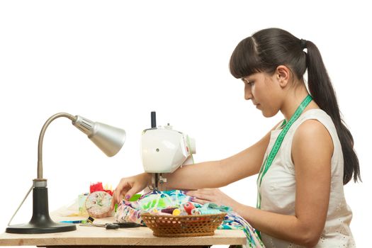 the seamstress sews a product on a table on the sewing machine