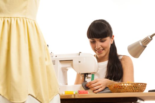 the seamstress sews a product on a table on the sewing machine