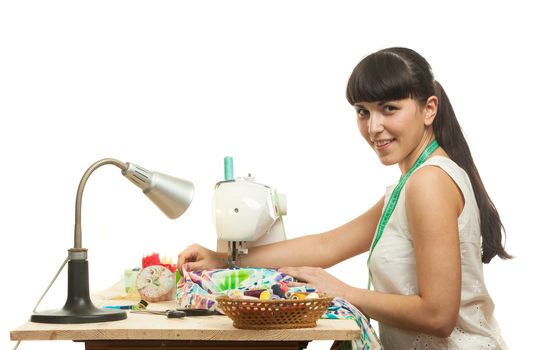 the seamstress sews a product on a table on the sewing machine