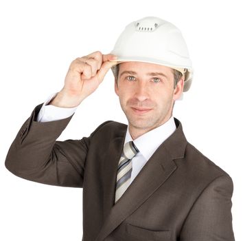 Businessman in suit raised his hard hat to greet, smiling to camera. Isolated on white background