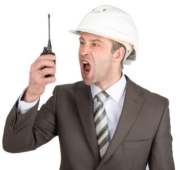 Businessman in suit and helmet screaming at walkie-talkie. Isolated on white background