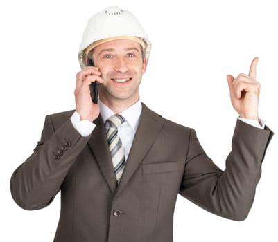 Happy businessman in helmet talking on mobile and looking at camera isolated on white background