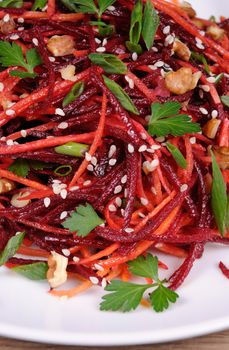 Salad of fresh grated carrots, beets, onions flavored with nuts and sesame seeds