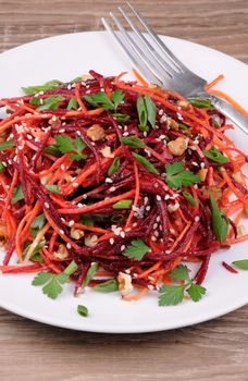 Salad of fresh grated carrots, beets, onions flavored with nuts and sesame seeds