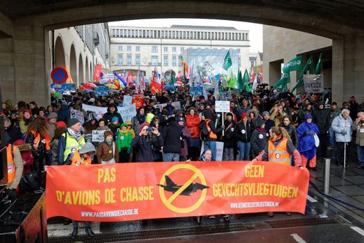 BELGIUM, Brussels: Protesters march behind a banner during a demonstration against fighters jets purchase plan in Brussels on April 24, 2016.