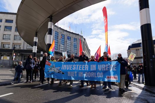 BELGIUM, Brussels: Protesters march behind a banner during a demonstration against fighters jets purchase plan in Brussels on April 24, 2016.