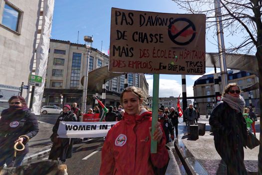 BELGIUM, Brussels: A protester holds a sign during a demonstration against fighters jets purchase plan in Brussels on April 24, 2016.