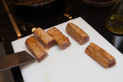 cook cut fried tuna slices on plastic platter