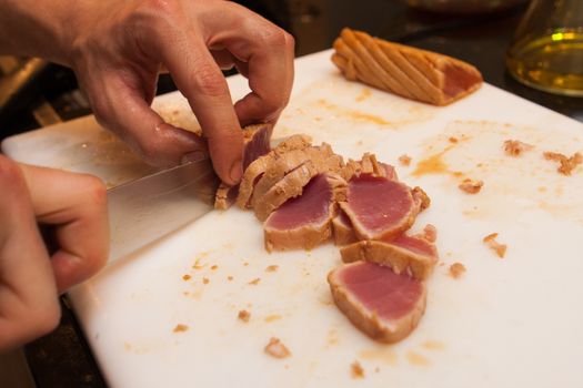 cook cut fried tuna slices on plastic platter