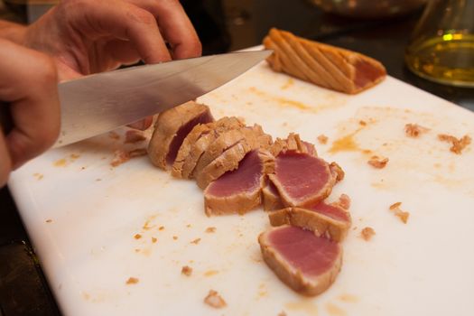 cook cut fried tuna slices on plastic platter