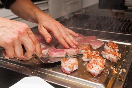 cook turn around grilled tuna meat on metallic pan