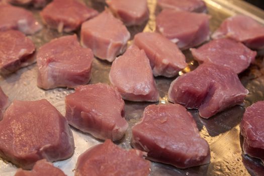 raw meat prepared for barbecue on metallic platter