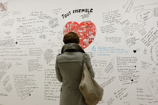 BELGIUM, Brussels : A woman reads messages on a commemorative wall at the Maelbeek - Maalbeek metro station on its re-opening day on April 25, 2016 in Brussels, after being closed since the 22 March attacks in the Belgian capital.Maelbeek - Maalbeek metro station was hit by one of the three Islamic State suicide bombers who struck Brussels airport and metro on March 22, killing 32 people and injuring hundreds.