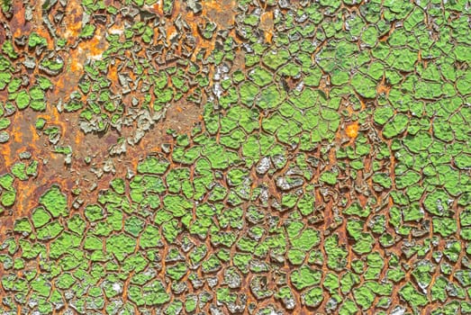 rusty iron surface covered with old chipped green color paint, which has long been influenced by different climatic conditions