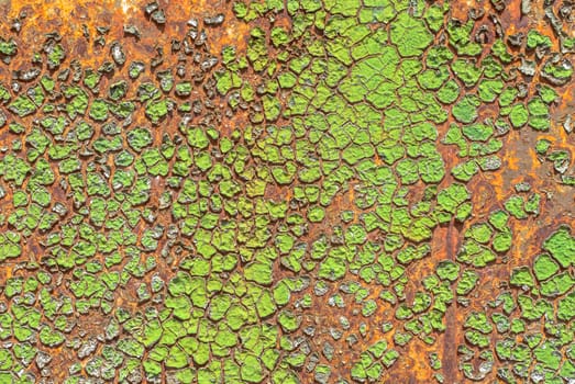 rusty iron surface covered with old chipped green color paint, which has long been influenced by different climatic conditions