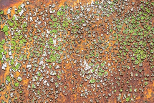 rusty iron surface covered with old chipped green color paint, which has long been influenced by different climatic conditions