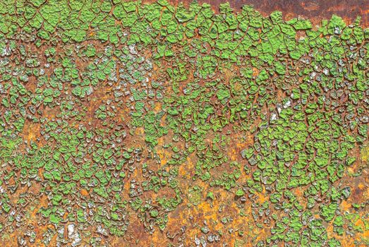 rusty iron surface covered with old chipped green color paint, which has long been influenced by different climatic conditions