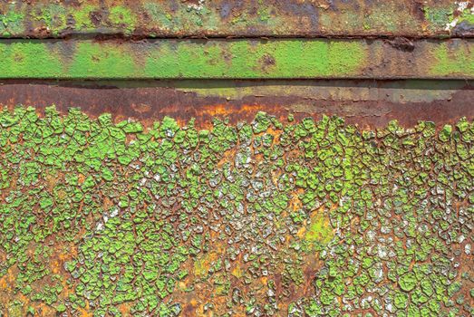 rusty iron surface covered with old chipped green color paint, which has long been influenced by different climatic conditions