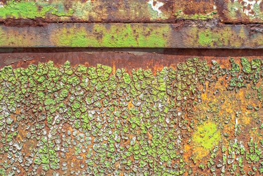 rusty iron surface covered with old chipped green color paint, which has long been influenced by different climatic conditions