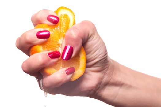 Hand with manicured nails painted a deep glossy red touch an orange on white background