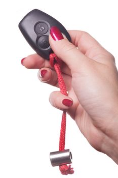 Close up of manicured hand with red nail polish holding black car key on white background