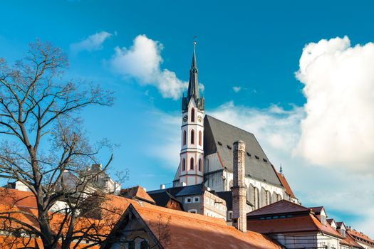 General Cesky Krumlov view with gothic towers and historical small houses around,  on bright sky background.