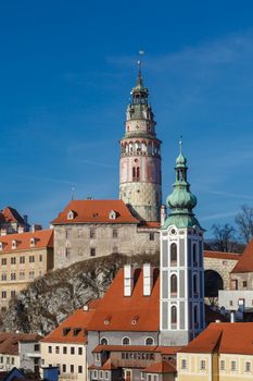 General Cesky Krumlov view with gothic towers and historical small houses around,  on bright sky background.