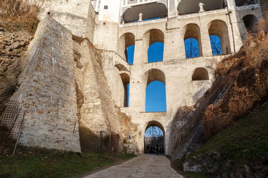 Close up detailed bottom view of Cloak Bridge on Upper Castle in Cesky Krumlow, Czech Republic, on bright blue sky background.