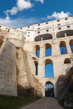 Close up detailed bottom view of Cloak Bridge on Upper Castle in Cesky Krumlow, Czech Republic, on bright blue sky background.