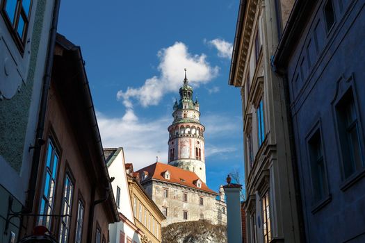 General view of Little Castle Tower in Cesky Krumlov, colorful historical tower on cloudy blue sky background.