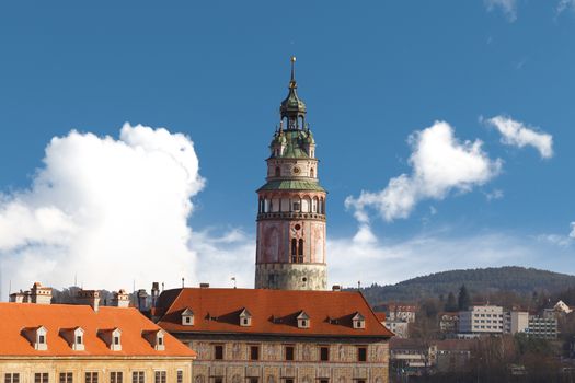 General view of Little Castle Tower in Cesky Krumlov, colorful historical tower on cloudy blue sky background.