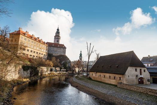 General view of Little Castle Tower in Cesky Krumlov, colorful historical tower on cloudy blue sky background.