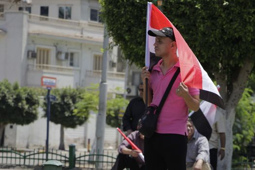EGYPT, Giza: A man holds a national flag as dozens gather in Mostafa Mahmoud Square in Giza, near Cairo on April 25, 2016 to commemorate the thirty-fourth anniversary of Sinai liberation. This same day, thousands of security personnel were deployed around Cairo ahead of mass planned protests over the return of two Red Sea islands to Saudi Arabia, a decision that has provoked some of the most open criticism of President Abdel-Fattah el-Sissi's leadership.