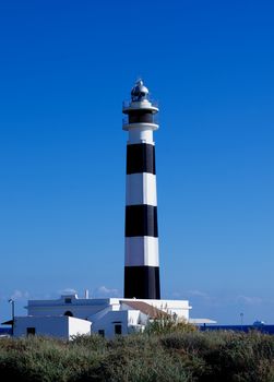 Cap de Artrutx Lighthouse on Clear Blue Sky background Outdoors. Southwest of Menorca, Balearic Islands