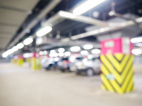 Parking garage underground with cars, industrial interior. Neon light in bright industrial building.